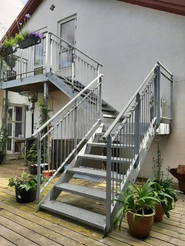 uma escada que leva a uma casa com vasos de plantas em The Loft. Studio-apartment in old farmhouse em Hundested