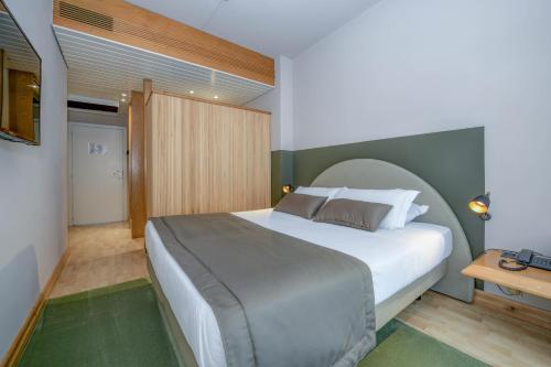 a bedroom with a large white bed and a table at Hotel City in Desenzano del Garda