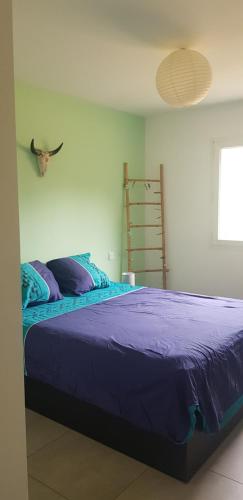 une chambre avec un grand lit avec des draps violets dans l'établissement Maison sur les hauteurs d'Ajaccio, à Valle-di-Mezzana