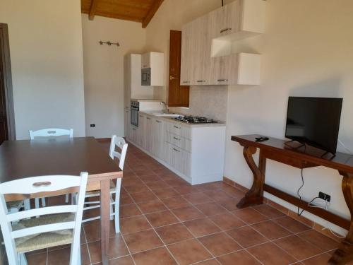 a kitchen with a table and a kitchen with white cabinets at Villa Paradiso in Montegiordano