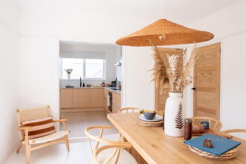 eine Küche und ein Esszimmer mit einem Holztisch mit einer Vase in der Unterkunft St Ives House Lowenek in St Ives
