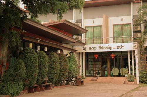 a building with a bunch of plants in front of it at Thai Lao Resort and Spa โรงแรมไทลาว รีสอร์ท แอนด์ สปา in Nakhon Phanom
