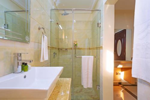 een badkamer met een wastafel en een douche bij West Lerruat Hotel in Nairobi