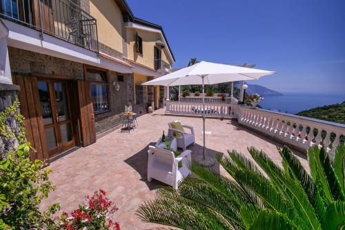 a patio with an umbrella and chairs on a building at Villa Costanza sorrento B&b in Sant'Agnello