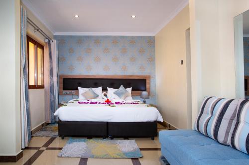 a bedroom with a large bed and a couch at West Lerruat Hotel in Nairobi