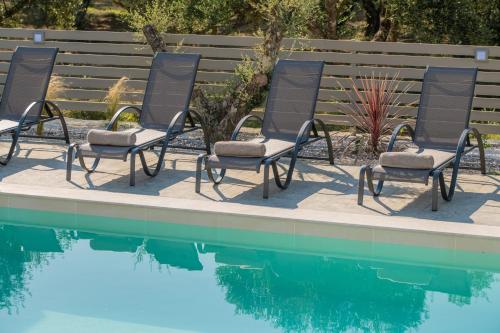 a group of chairs next to a swimming pool at Valentino Luxury Villa in Plános