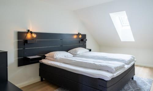 a bed with a black headboard in a bedroom at Town Square in Tromsø