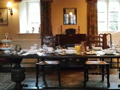 een eetkamer met een tafel met gerechten erop bij Lower Severalls Farmhouse in Crewkerne