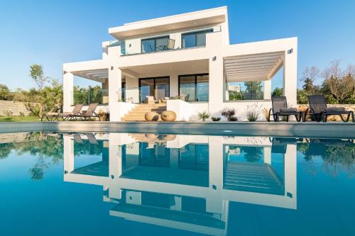 a house with a pool in front of it at Valentino Luxury Villa in Plános