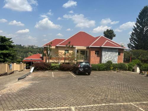 a house with a car parked in a parking lot at CENTRE D ACCUEIL HOSANNA in Kigali