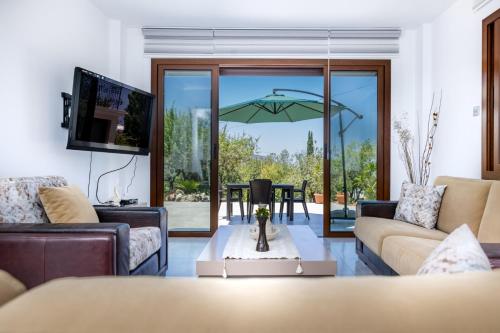 a living room with a couch and an umbrella at Bellapais Apartments in Kérynia