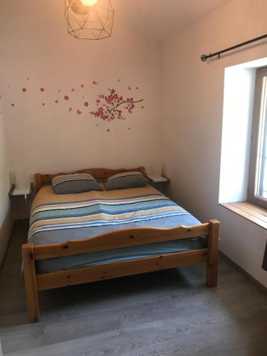 1 dormitorio con 1 cama con flores en la pared en Le grenier de l Aigoual en Valleraugue
