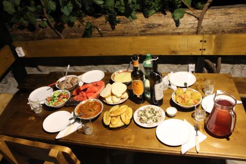 einen Tisch mit Teller mit Lebensmitteln und Flaschen Wein in der Unterkunft Likani-house's Cottage in Bordschomi