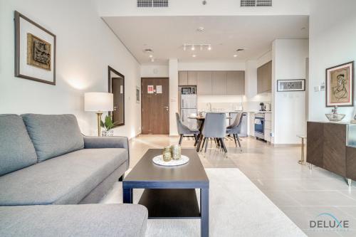 a living room with a couch and a table at Graceful 1BR at Park Heights Dubai Hills MBR City by Deluxe Holiday Homes in Dubai