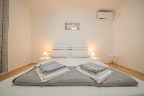 une chambre blanche avec un lit avec des serviettes dessus dans l'établissement Villa Karmen - Poolhouse, à Vir