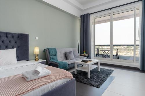 a bedroom with a bed and a chair and a window at Vacay Lettings - Silicon Oasis Budget Friendly Studio in Dubai