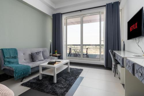 a living room with a couch and a table at Vacay Lettings - Silicon Oasis Budget Friendly Studio in Dubai