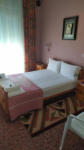 a bedroom with a large bed and a window at Hotel Angela in Asprovalta