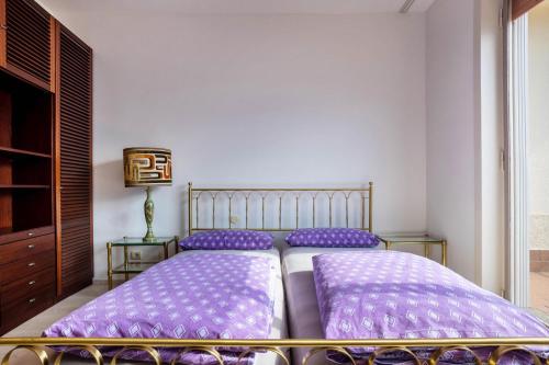 a bedroom with two beds with purple pillows at Wohnung mit grandiosem Ausblick in Tremosine Sul Garda