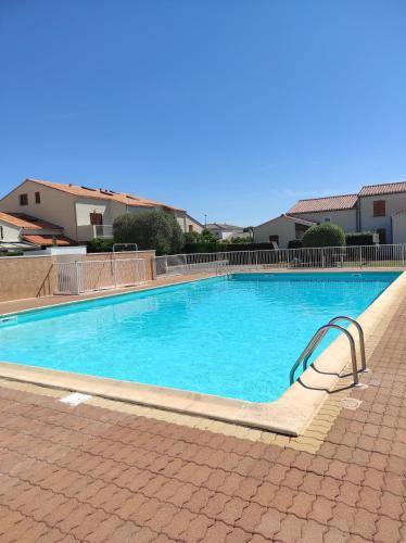 une grande piscine bleue dans un immeuble dans l'établissement Au mouillage, appartement 2 pièces plage de Pontaillac, à Vaux-sur-Mer