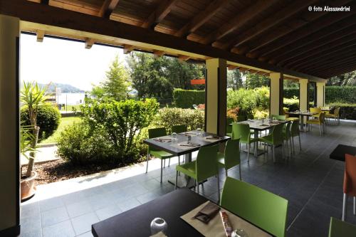 a restaurant with tables and green chairs on a patio at Camping Rose in Dormelletto
