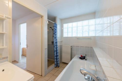 y baño con bañera, ducha y lavamanos. en Grimaud 185 - Kustpark Village Scaldia, en Hoofdplaat