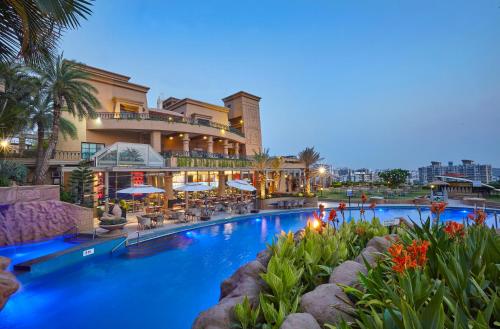 uma piscina num hotel com um resort em The Corinthians Resort & Club em Pune