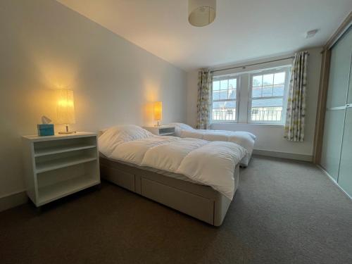 1 dormitorio con 2 camas y ventana en Luxury 2-bedroom apartment near beach in St Andrews, en St Andrews