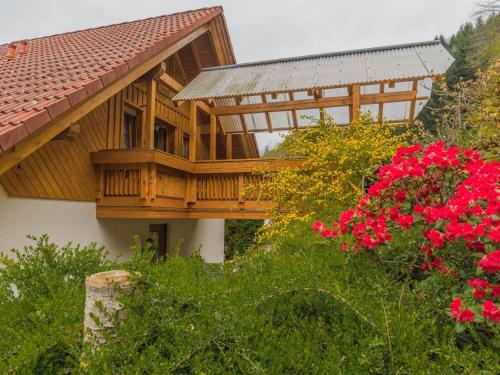 Casa de madera con balcón y flores rojas en Haus Sigmund, en Oberharmersbach