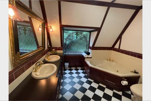 a bathroom with two sinks and a bath tub at Fernhill Estate “ Gingerbread House” in Kallista