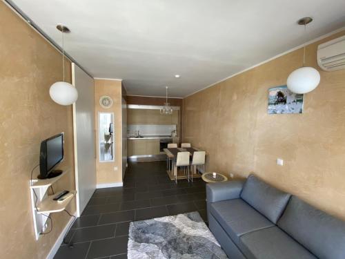 sala de estar con sofá azul y TV en Yoo Bulgaria Apartments -c306 en Obzor