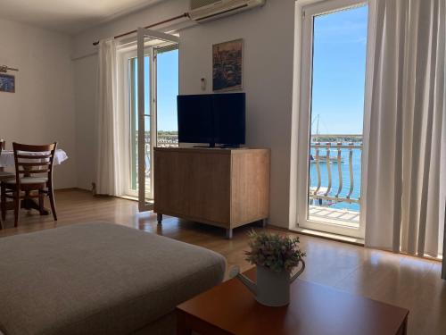 a living room with a television and a large window at Villa Adria in Vodice