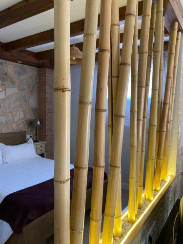 a room with a bed and bamboo poles at Alojamiento Cerro Socorro in Cuenca