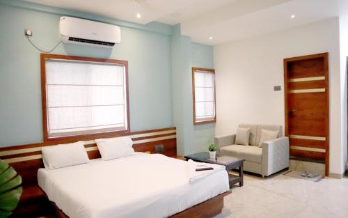 a bedroom with a bed and a couch and a chair at Hotel United House in Shirdi