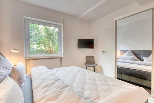 a bedroom with a bed and a window and a mirror at Haus Kleemann E24 in Norderney
