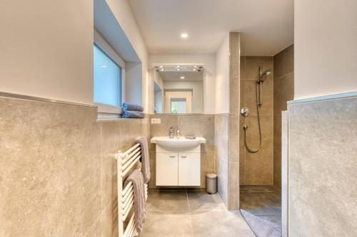 y baño con lavabo y ducha. en Haus Kleemann E24 en Norderney