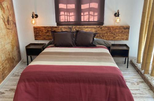 een slaapkamer met een groot bed met 2 nachtkastjes bij La Casita in Ventas de Zafarraya