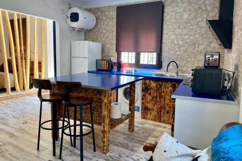 a kitchen with a counter and a blue counter top at La Casita in Ventas de Zafarraya
