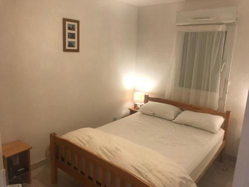 une chambre avec un lit avec des draps blancs et une fenêtre dans l'établissement CORTADERIA B002, à Saint-Cyprien