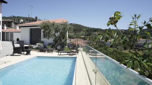 a swimming pool in front of a house at Casas do Aidro in Freches