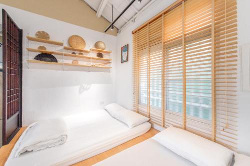 a room with two beds and a window at 安平福巷人文家宿 Anping Hok Hāng in San-k'un-shen