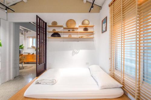 a bedroom with a bed in a room with shelves at 安平福巷人文家宿 Anping Hok Hāng in San-k'un-shen