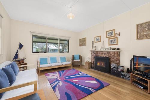 a living room with a fireplace and a tv at Oak And Pine in Apollo Bay