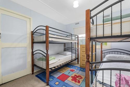a room with three bunk beds and a doorway at Oak And Pine in Apollo Bay