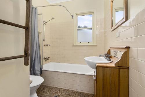a bathroom with a tub and a sink and a toilet at Oak And Pine in Apollo Bay