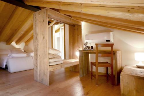 a bedroom with a bed and a desk in a attic at Asolo Norah's Hill Agri Rooms in Caenere