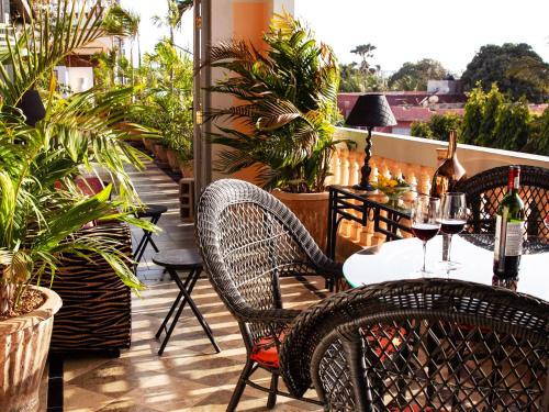 a patio with a table and chairs with wine glasses at RoofTop Boutique Hotel Adults Only in Serekunda