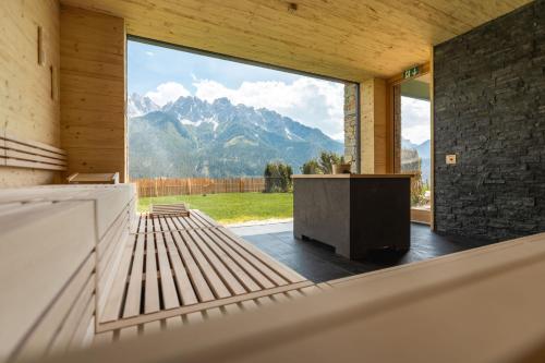 a room with a large window with a view of mountains at Hotel Schopfenhof in San Candido