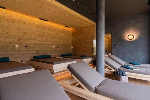 a room with two beds and a bathtub at Hotel Schopfenhof in San Candido