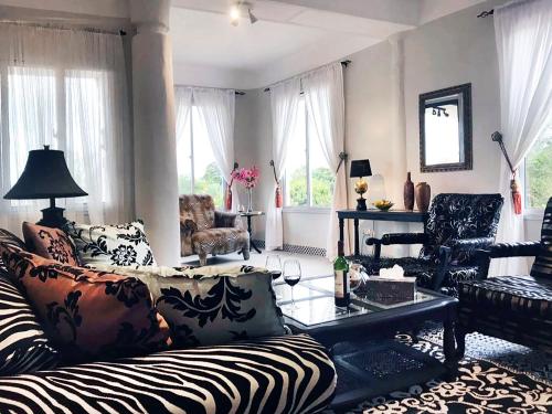uma sala de estar com um sofá com estampa de zebra e cadeiras em RoofTop Boutique Hotel Adults Only em Serekunda